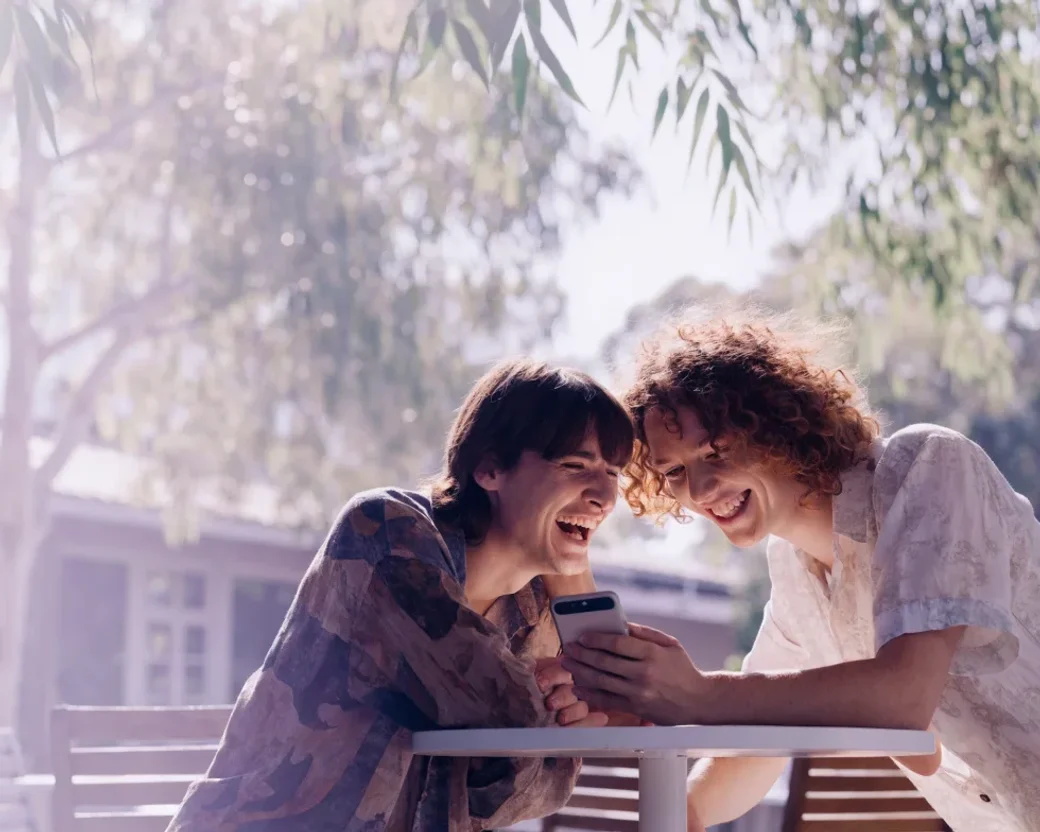 Two Digital Surge customers at a cafe looking at the app together