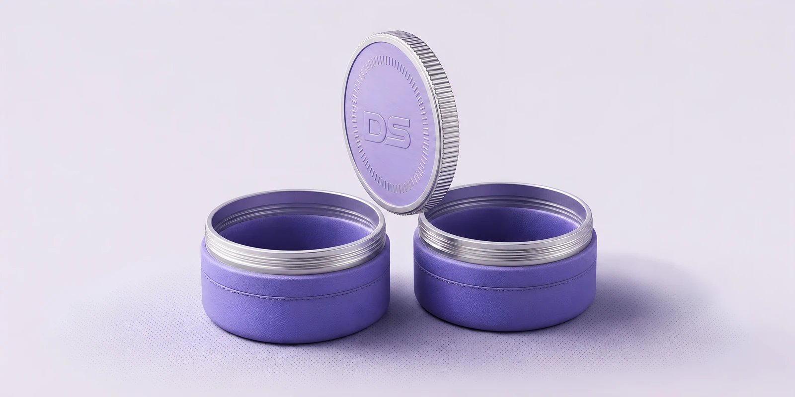 A coin poised on edge above two open violet canisters